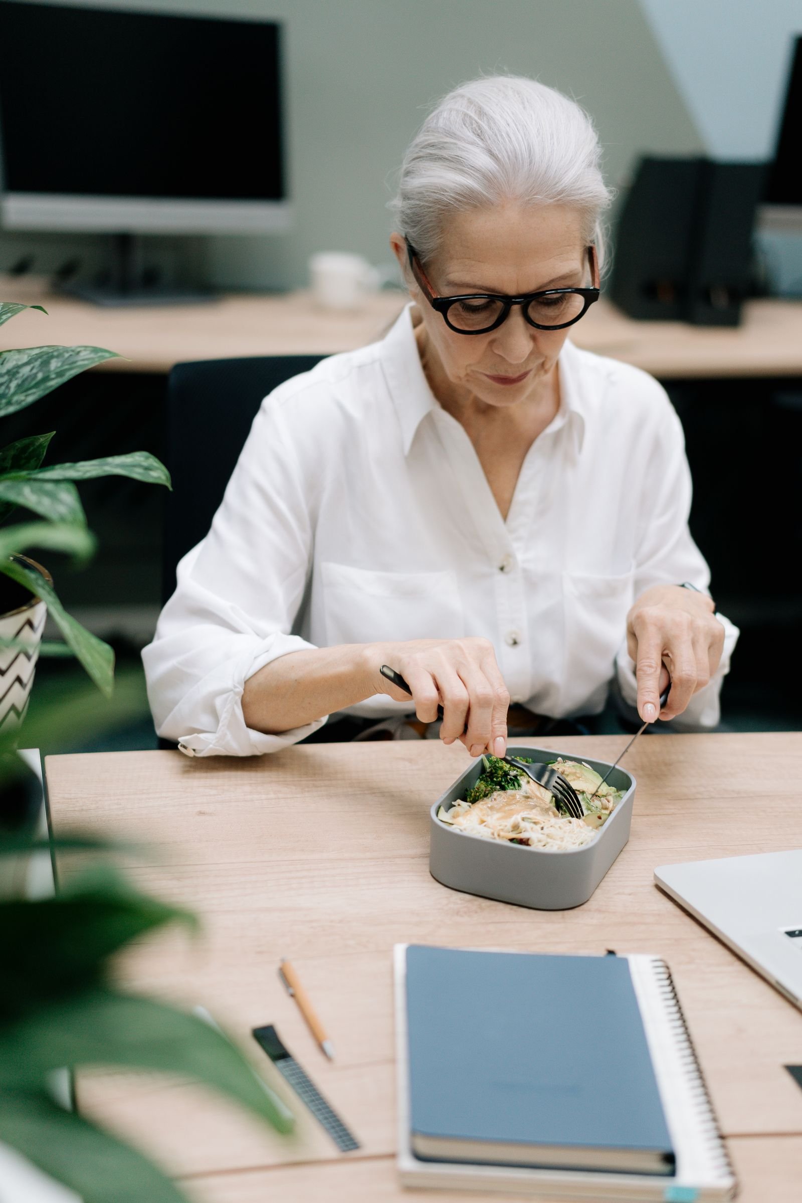 Collaboratrice dégustant son repas livré directement à son bureau